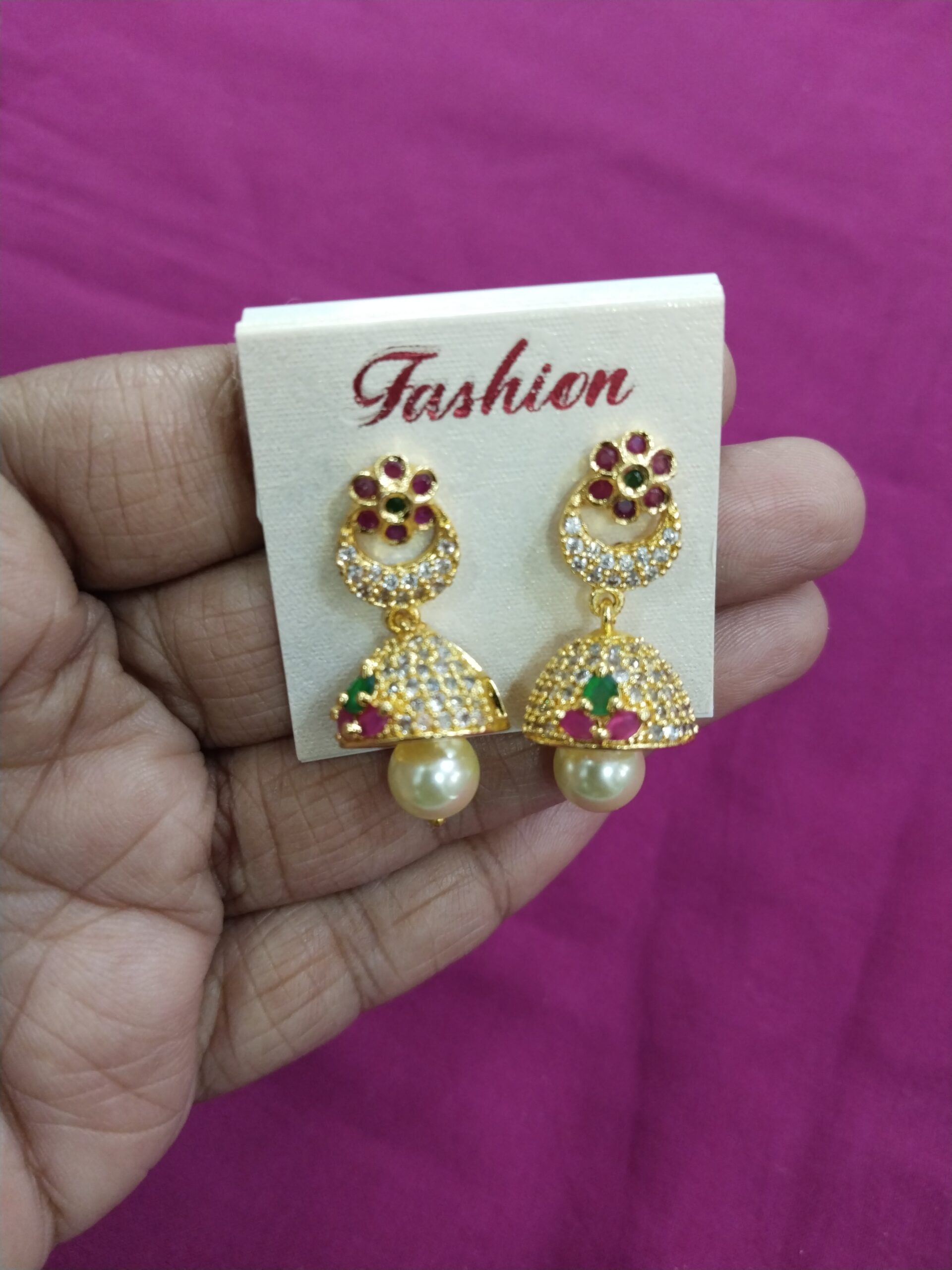 Festive Gold Jhumkas with Pink Oval Stone and White CZ Accents